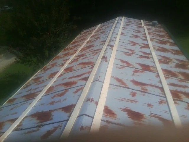 Rusted metal roof panels with new wood purlins before replacement — Storm Damage Roof Repair in Faulkner by Roofing Brothers