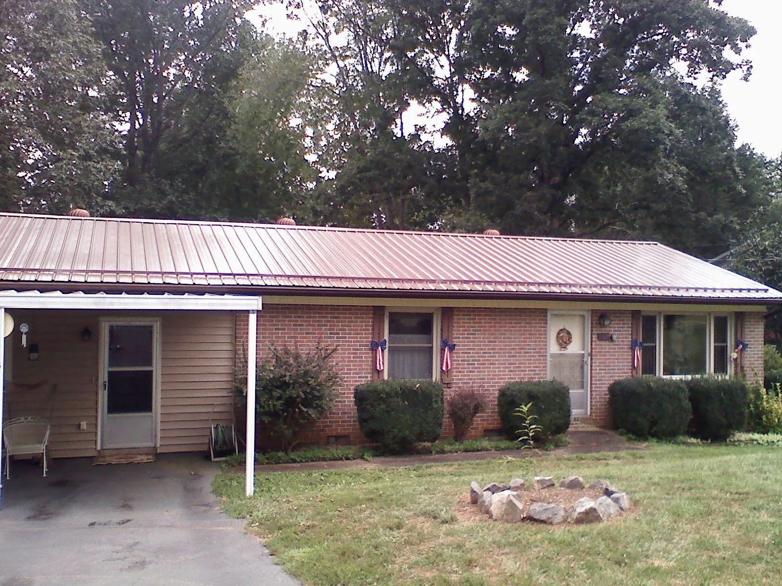 Bronze metal roof and carport on a brick ranch home — Roof Repair work by our crew in Faulkner